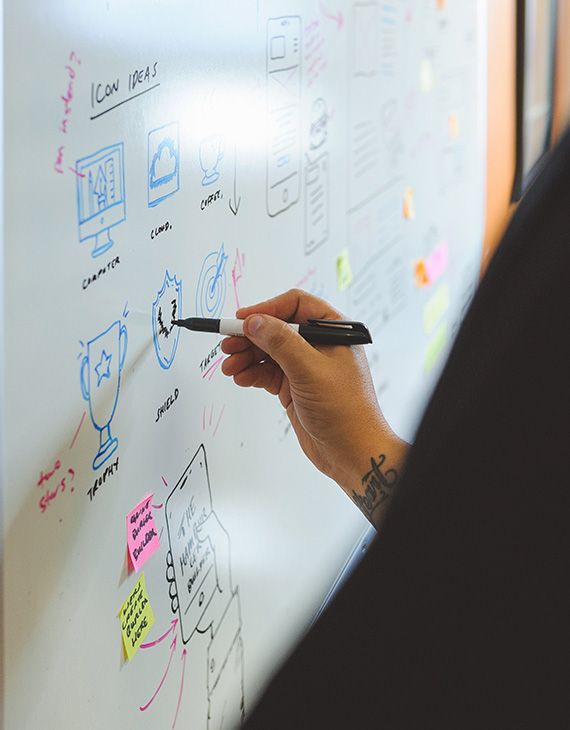 REM designers and developers brainstorming in front of a whiteboard